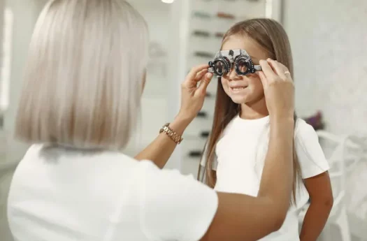 doświadczona fizjoterapeutka wykonuje badanie wzroku pacjentce pediatrycznej